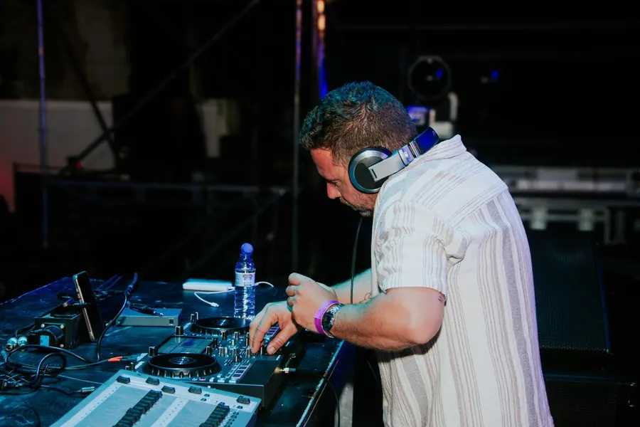 Camolas DJ a misturar música num controlador Numark em palco